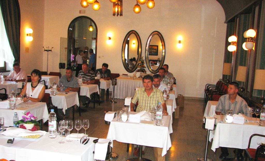 The judging panel at their tables with glasses during the wine tasting